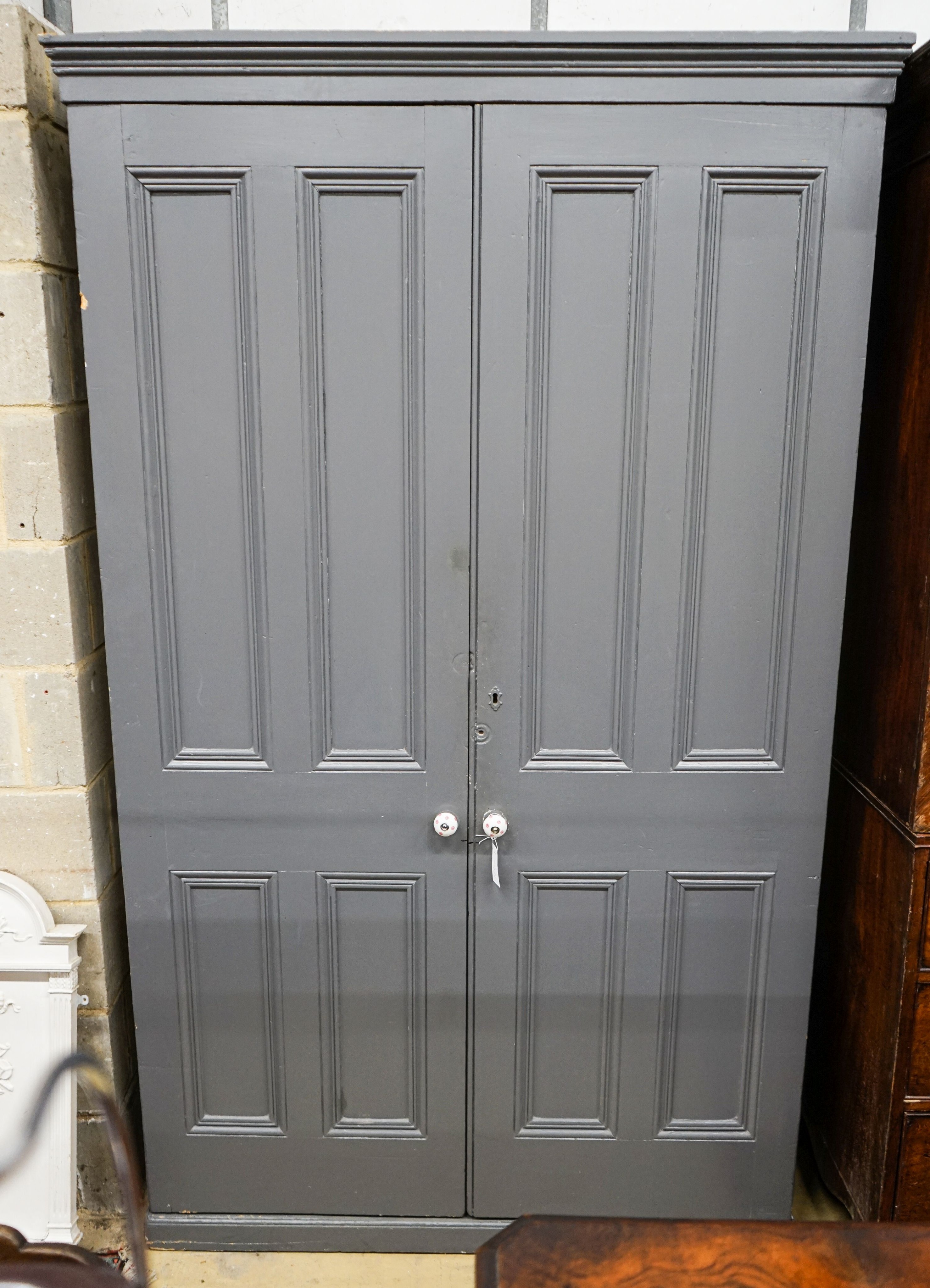A Victorian painted panelled pine two door housekeeper's cupboard, width 130cm, depth 40cm, height 214cm